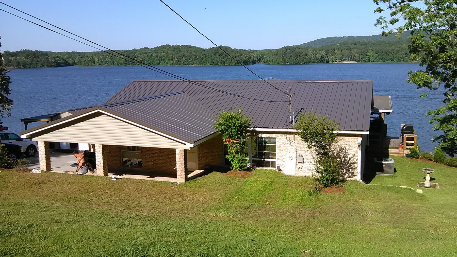 Lakeside home with a dark metal roof and covered outdoor area
