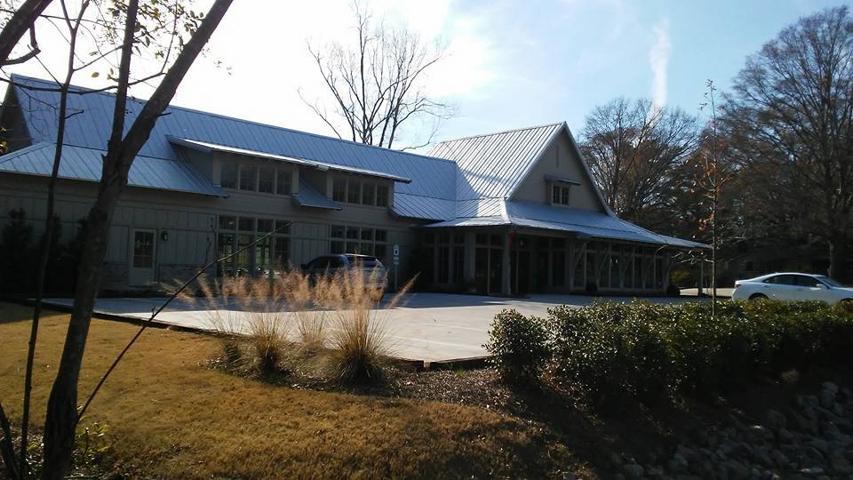 Large building exterior renovation with updated roofline and entrance
