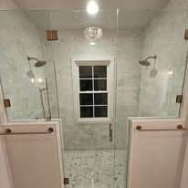 Tile shower renovation with glass enclosure and dual vanities