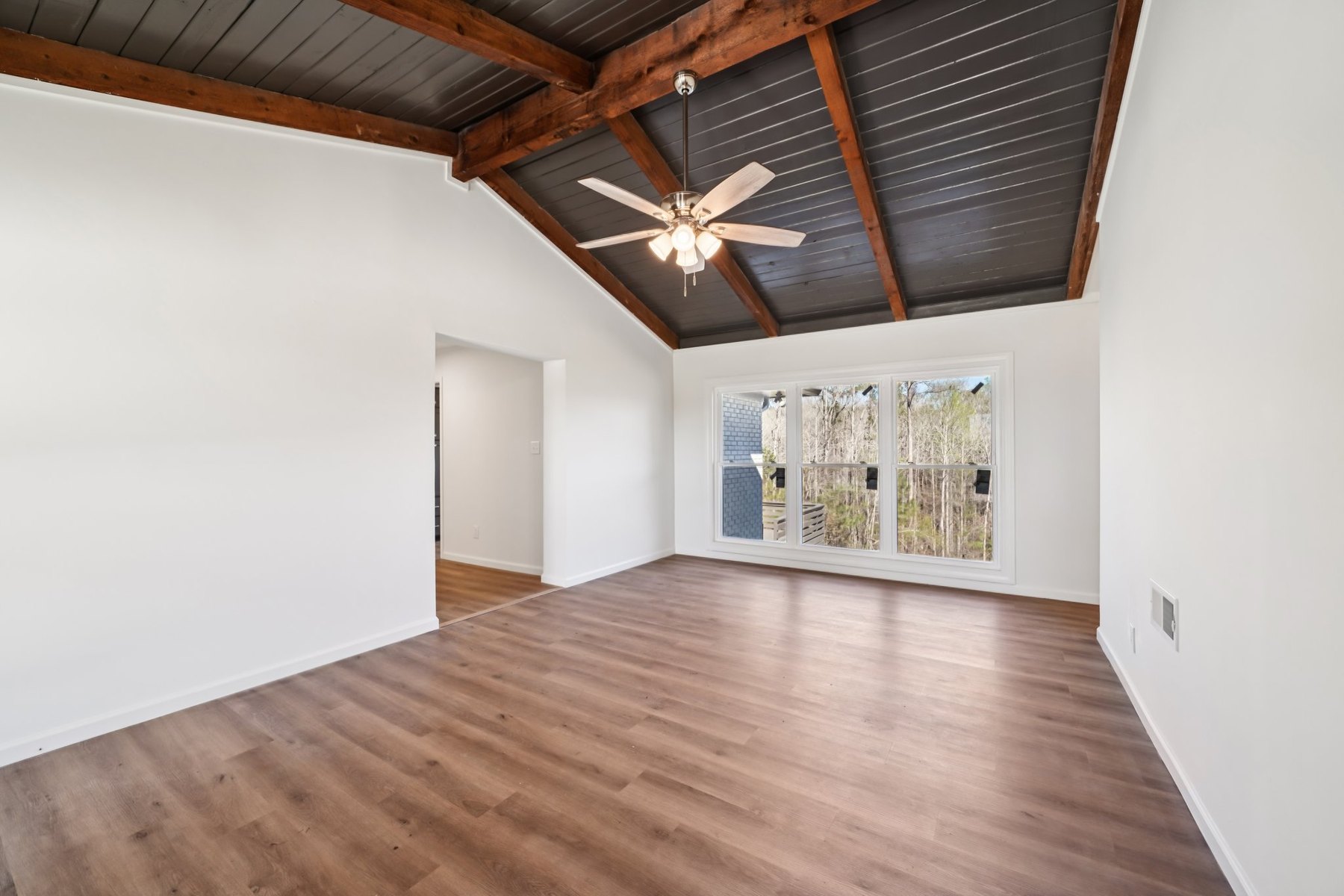 Restored interior room with wood flooring and vaulted wood ceiling