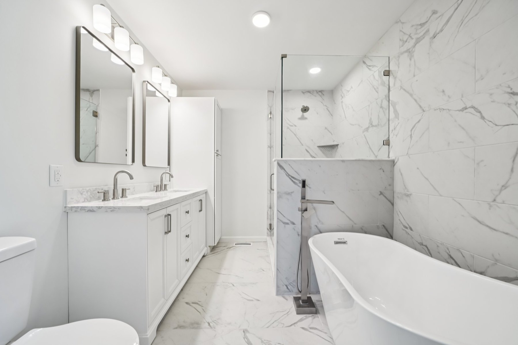 Bright bathroom renovation with double vanity, shower, and freestanding tub