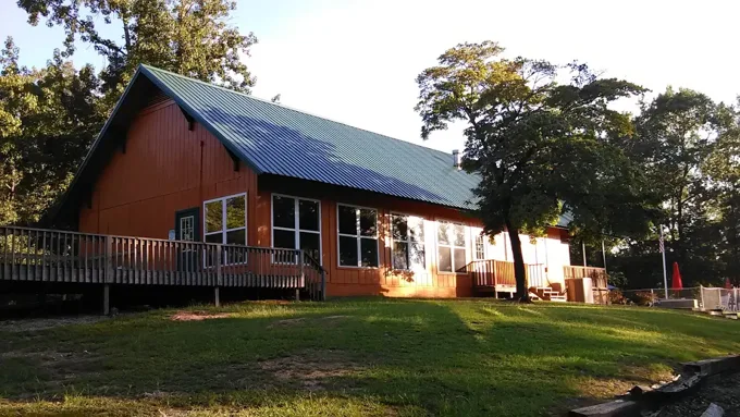 Green metal roof on an orange home with a wraparound deck
