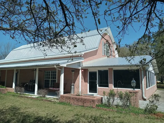 Metal roof over a brick home and porch