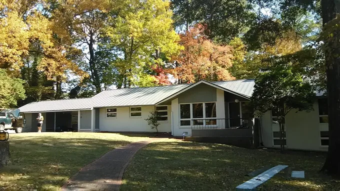 Metal roof on a single-story home surrounded by autumn trees