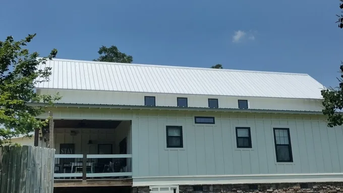 Light metal roof above white siding and dark window trim