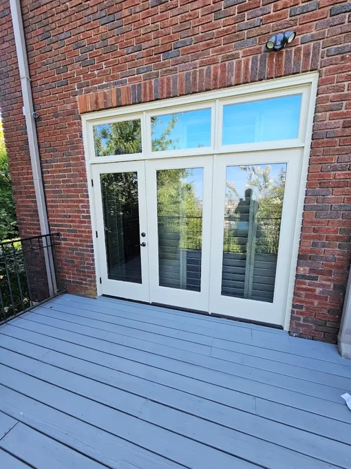 White patio doors and transom windows opening onto a painted deck